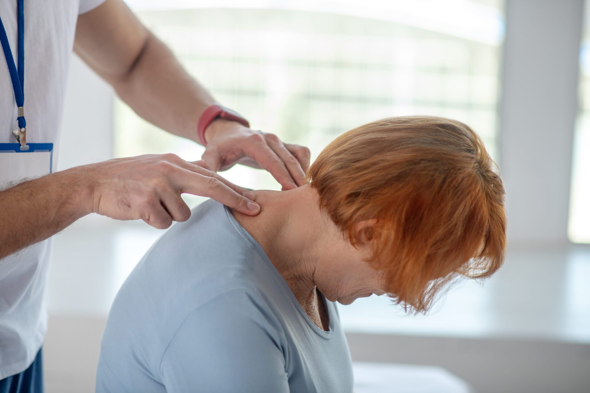 An image of a patient leaning her head forward while undergoing a medical procedure